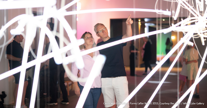 Man and woman stood looking at a light artwork inside The Light Durham.